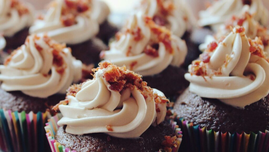 Chocolate cupcakes with bacon and whipped cream.