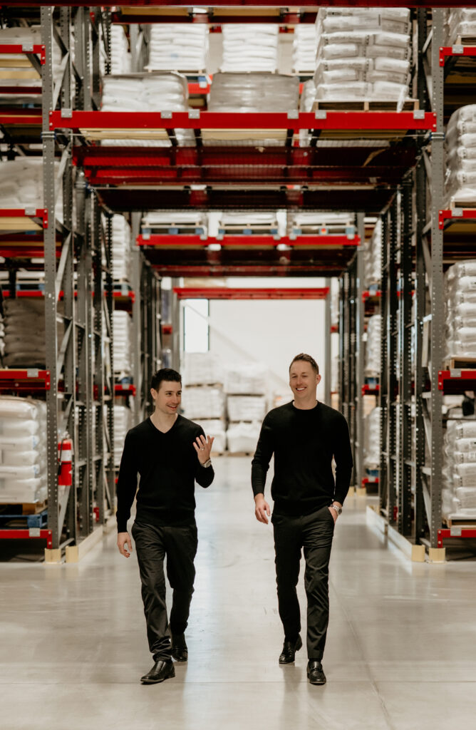 Two men walking through a warehouse.