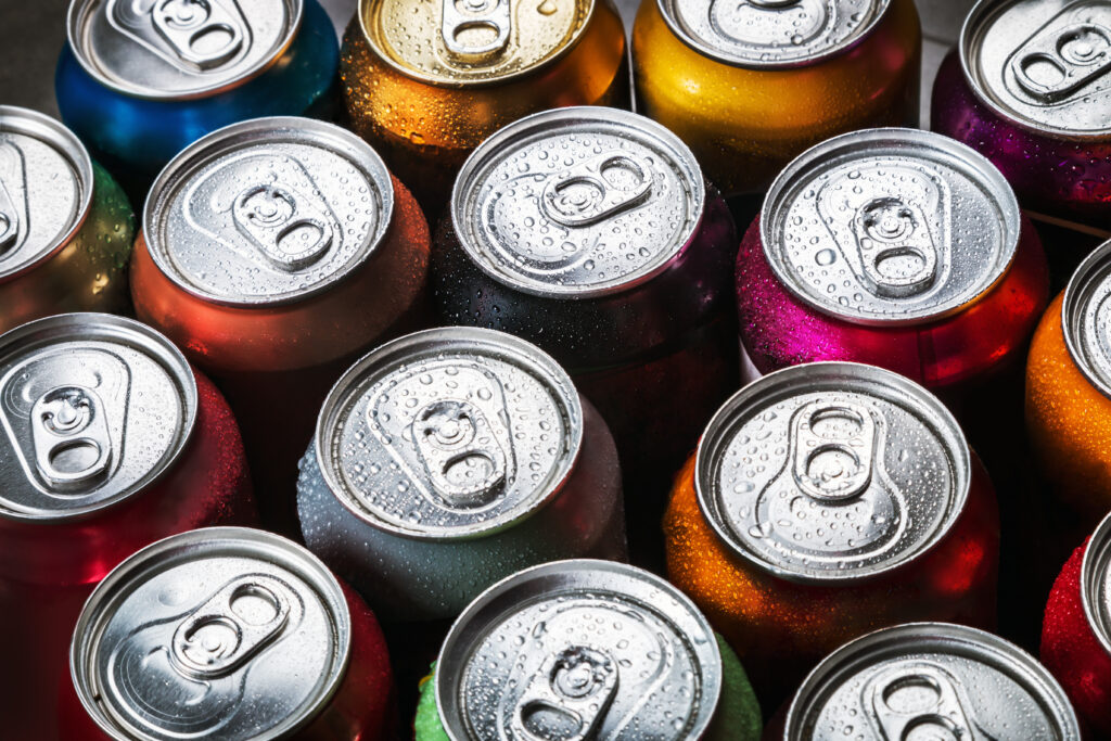 Many cans of soda are arranged in a row, showcasing the cost savings of beverage wraps.