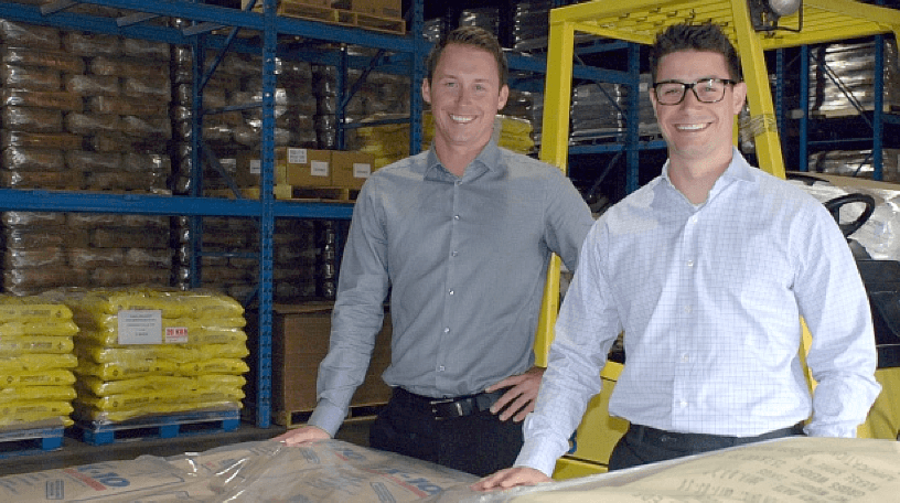 Steve Zinger and Rob Bianchin standing next to a forklift in a Blendtek food ingredient warehouse.