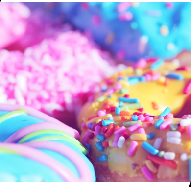 Colorful sprinkled donuts on a black background.