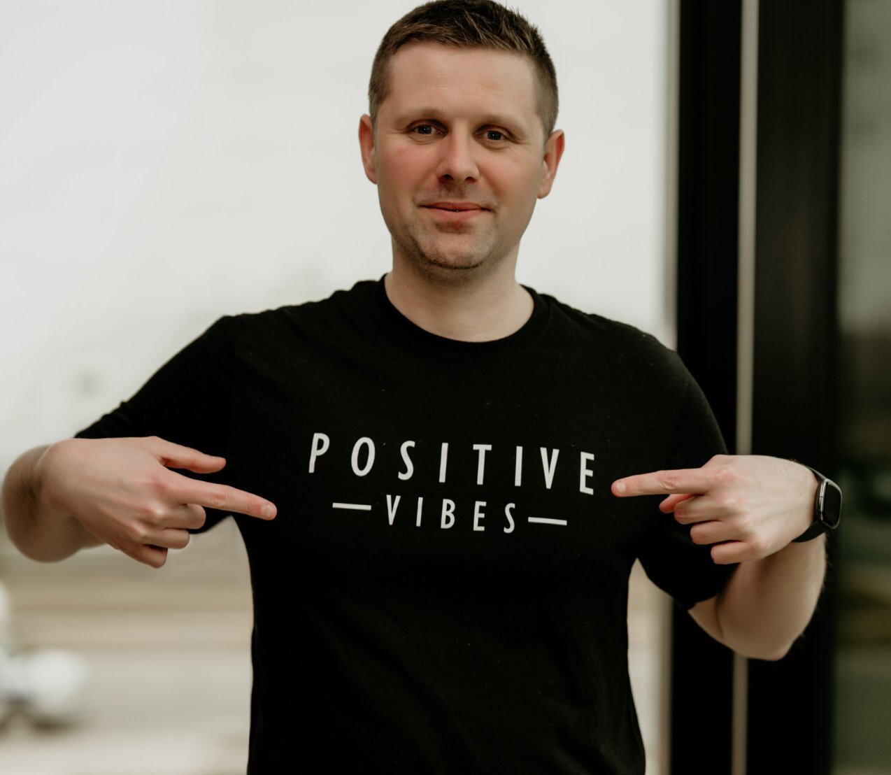 A man wearing a t - shirt that says positive vibes.